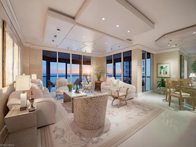 Grand Living area with evening sunset views of the gulf waters and beach with custom recessed lighting, and crown molding.