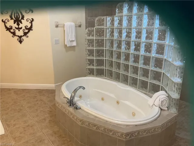 Full bath with a tub with jets, tile patterned floors, and a walk in shower