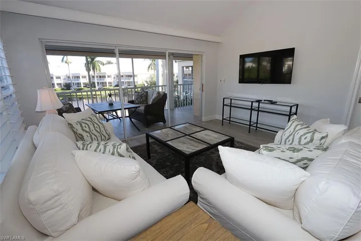 Living area with lofted ceiling and wood finished floors