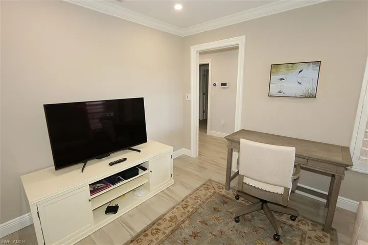 Office featuring light wood-style flooring, crown molding, and recessed lighting