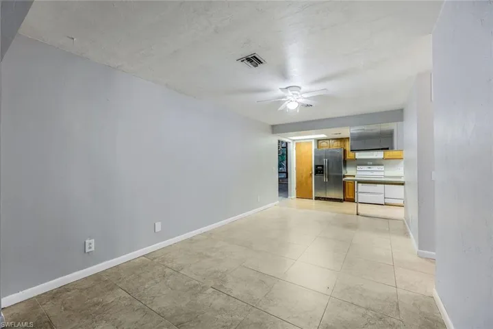 Unfurnished room featuring ceiling fan and light tile floors
