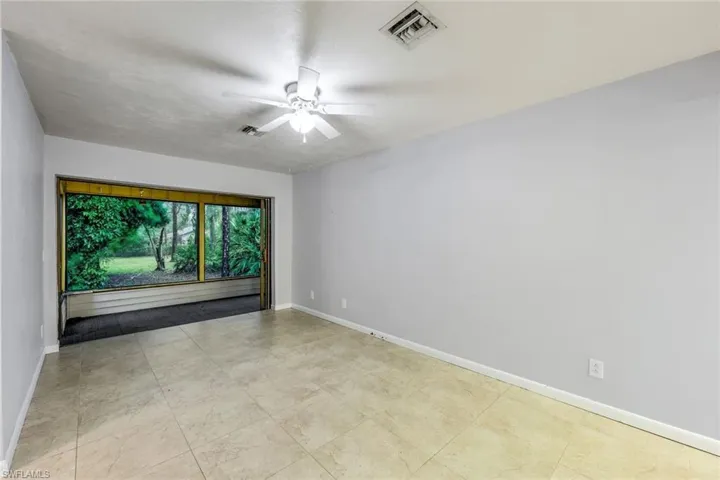 Empty room featuring ceiling fan and light tile flooring