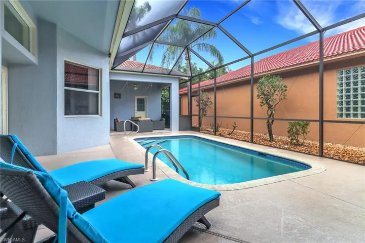 Outdoor pool featuring a patio, an outdoor living space, and glass enclosure