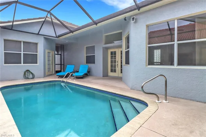 Outdoor pool with french doors, a patio area, and a lanai