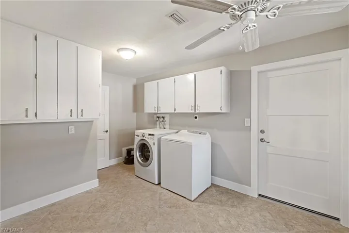 Laundry area with cabinet space, a ceiling fan, and separate washer and dryer