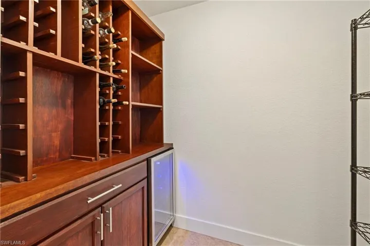 Wine room featuring beverage cooler and a textured wall
