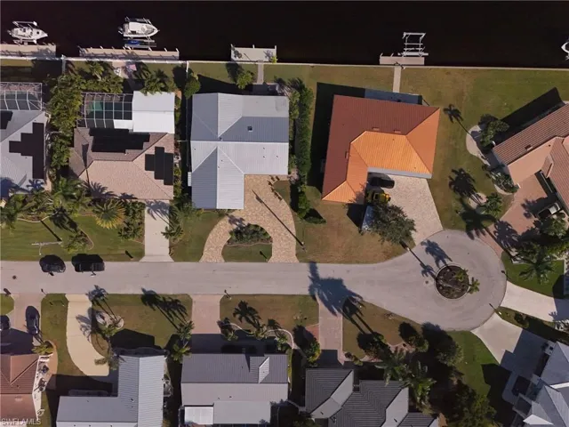 Aerial view of property and surrounding area featuring nearby suburban area