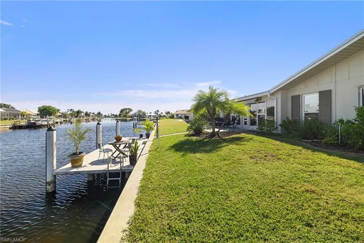 Dock with a water view, a yard, and a residential view