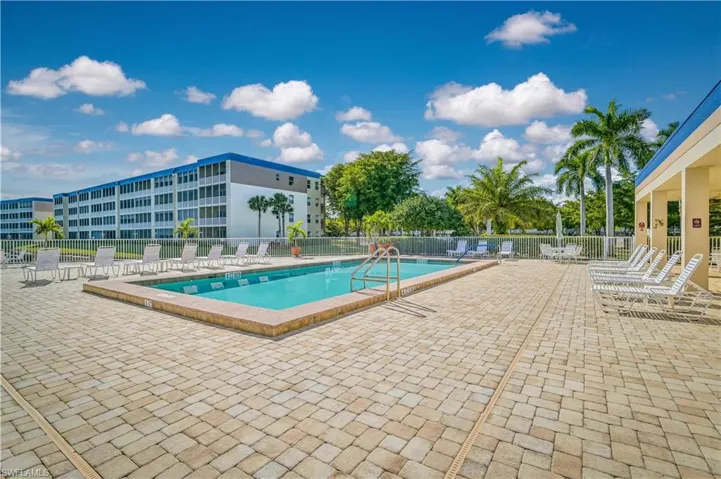 Community pool featuring a patio area and fence