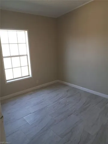 Empty room featuring a textured ceiling and wood finished floors