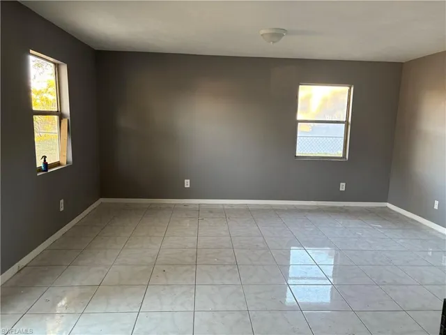 Living room with baseboards and light tile patterned flooring