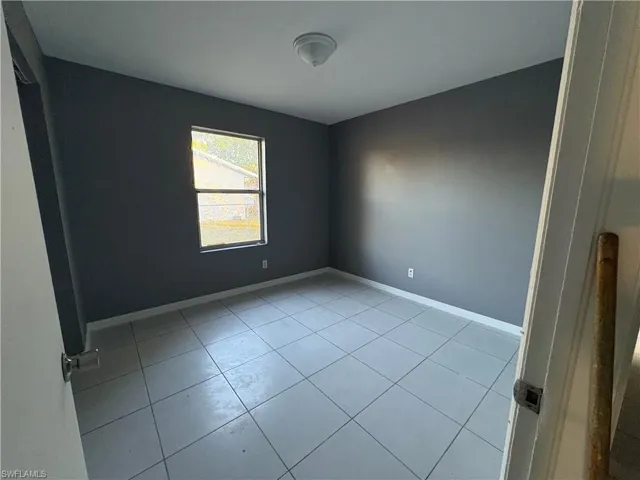 Spare room featuring baseboards and light tile patterned floors