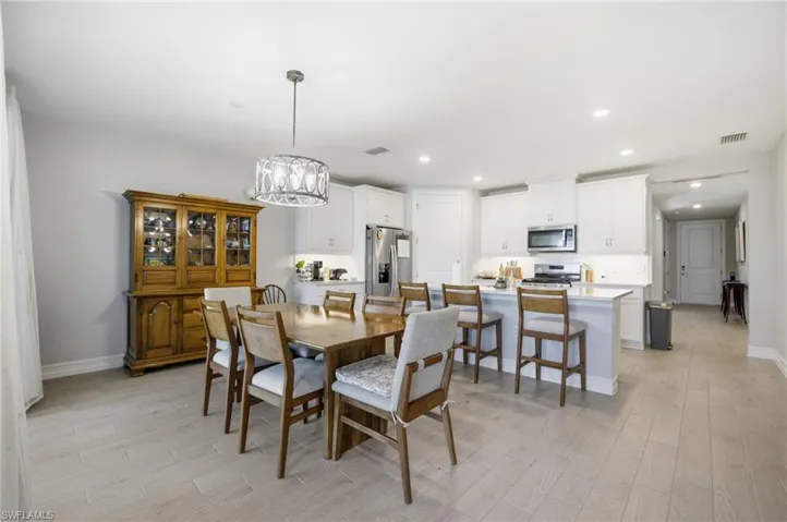Dining area featuring light wood-type flooring, a chandelier, and recessed lighting