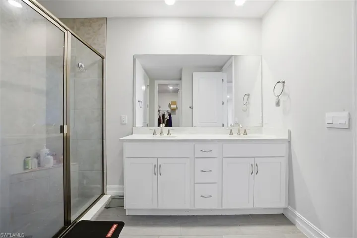 Bathroom with double vanity and a stall shower