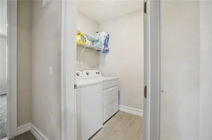 Laundry room featuring light wood-style floors and separate washer and dryer