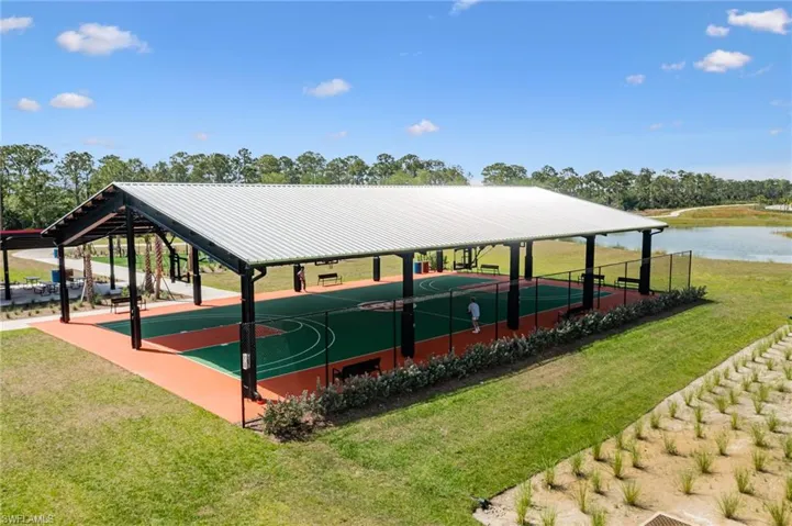View of property's community with a lawn, a patio, community basketball court, and view of scattered trees
