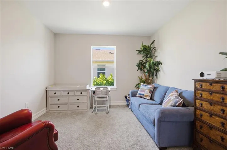 Living area featuring baseboards and carpet
