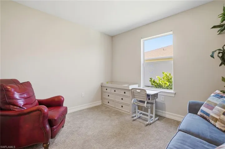 Living area with light carpet and baseboards
