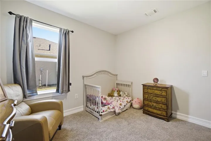 Carpeted bedroom featuring baseboards and radiator