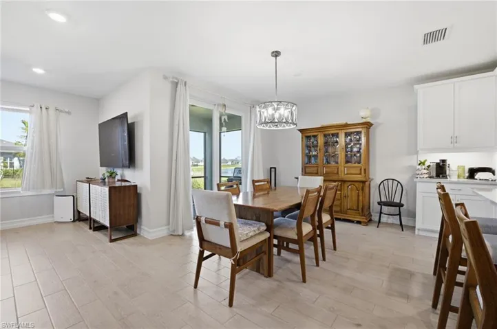 Dining space featuring light wood-style floors, a chandelier, plenty of natural light, and recessed lighting