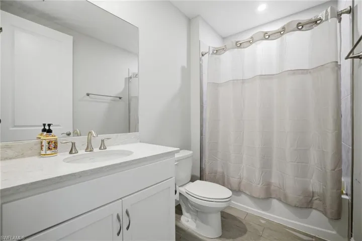 Bathroom featuring shower / bath combo with shower curtain and vanity