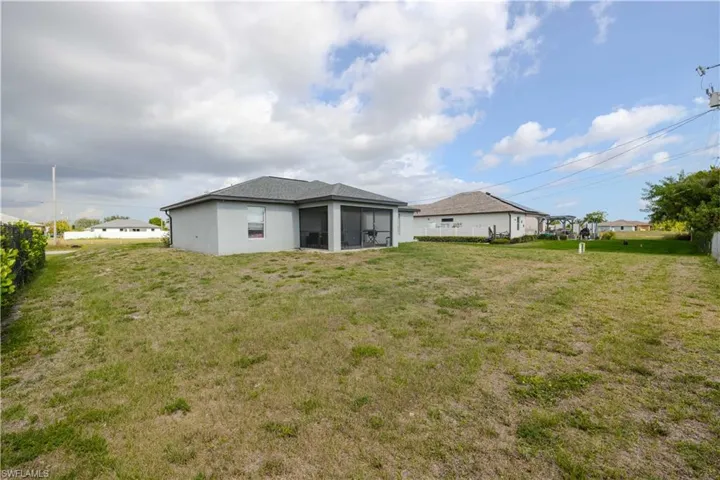 Back of property featuring a sunroom and a lawn