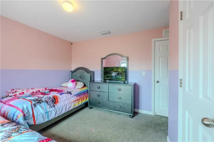 Bedroom featuring light colored carpet and baseboards