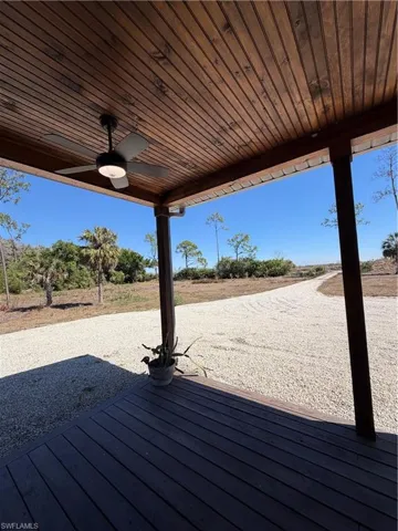 Wooden terrace featuring a ceiling fan