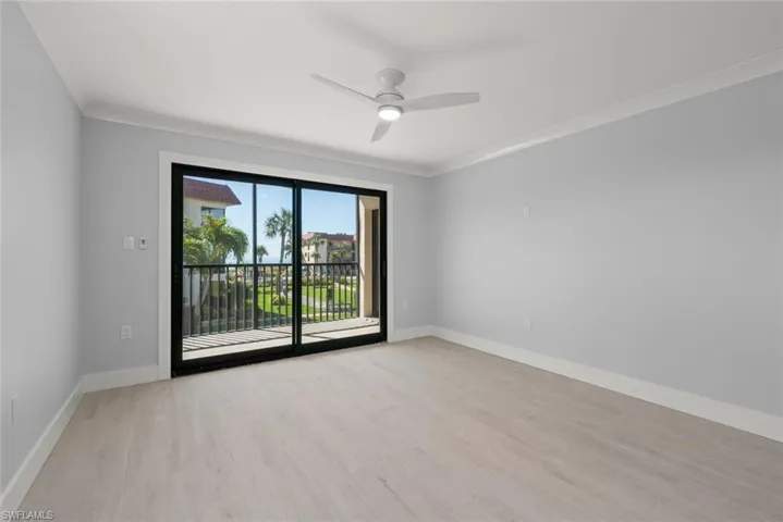 Spare room featuring ornamental molding, light wood-type flooring, and ceiling fan