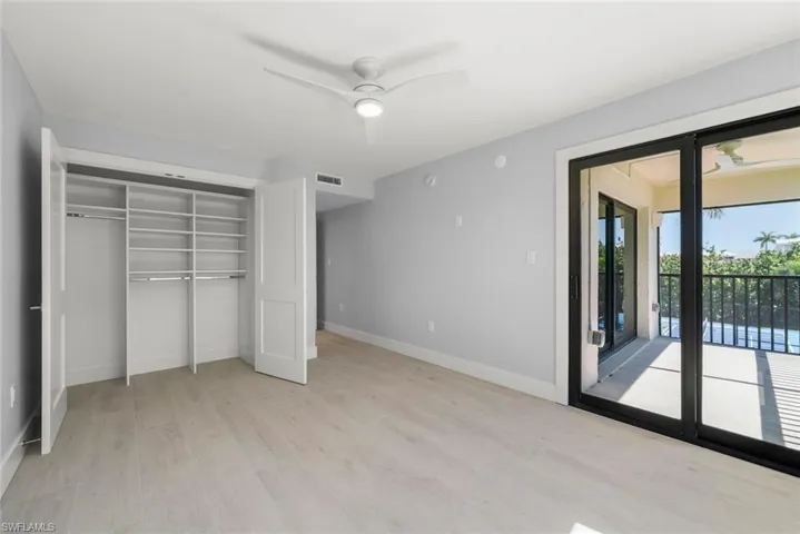 Unfurnished bedroom with light wood-style flooring, access to exterior, a closet, and a ceiling fan