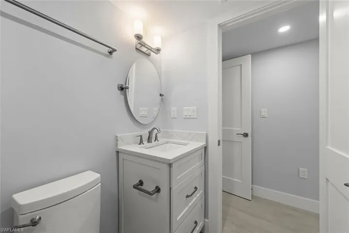 Half bathroom featuring vanity, recessed lighting, and light wood-type flooring