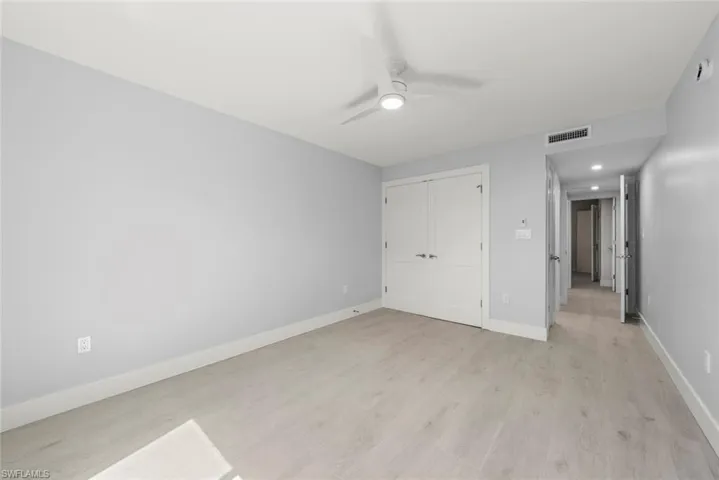 Unfurnished bedroom with light wood-style floors, ceiling fan, a closet, and recessed lighting