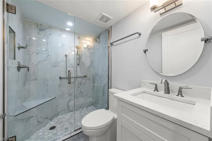 Full bathroom with vanity and a marble finish shower