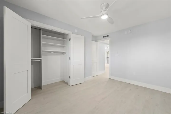 Unfurnished bedroom featuring light wood finished floors, a ceiling fan, and a closet