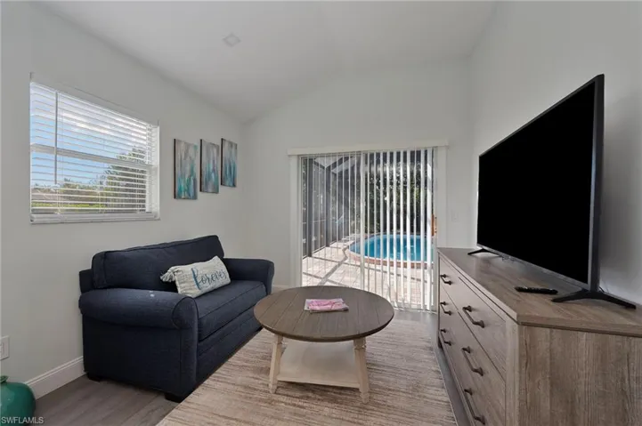 Living area with vaulted ceiling and light wood-type flooring