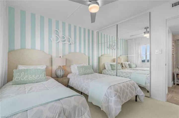 Second bedroom features twin beds, mirrored bi-pass closet doors with closet system.