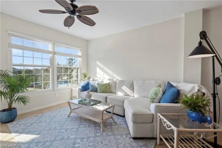 Living area with baseboards and ceiling fan