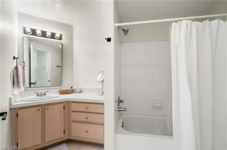 Full bathroom with shower / bath combo, vanity, and light tile patterned floors