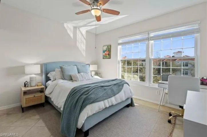 Bedroom featuring ceiling fan, a desk, and light tile patterned flooring