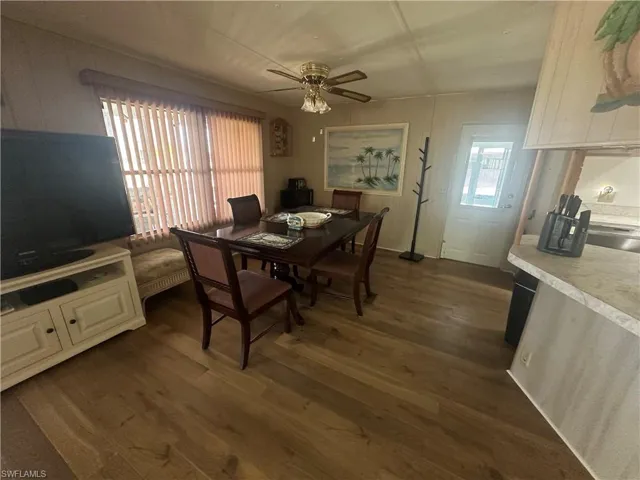 Dining area with dark wood-type flooring and a ceiling fan