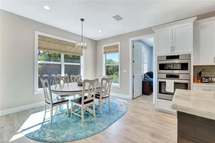 Dining space with light wood finished floors, visible vents, baseboards, a chandelier, and recessed lighting