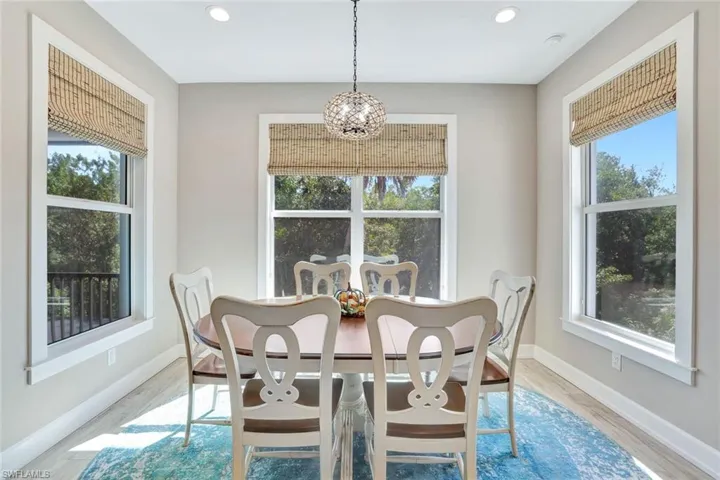 Dining room with a notable chandelier, a healthy amount of sunlight, and wood finished floors