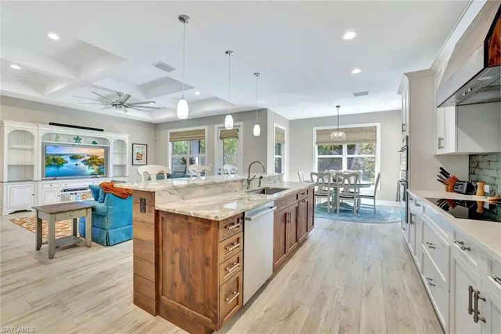 Kitchen with ventilation hood, visible vents, a sink, dishwasher, and black electric stovetop