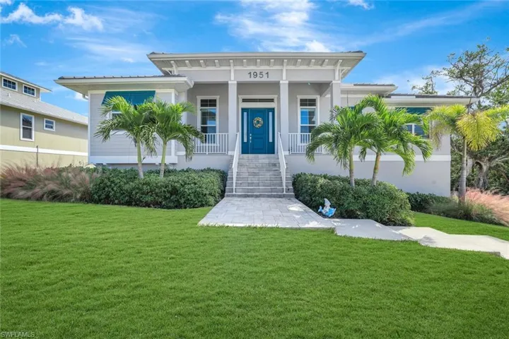 Property entrance featuring a yard, a porch, and stucco siding