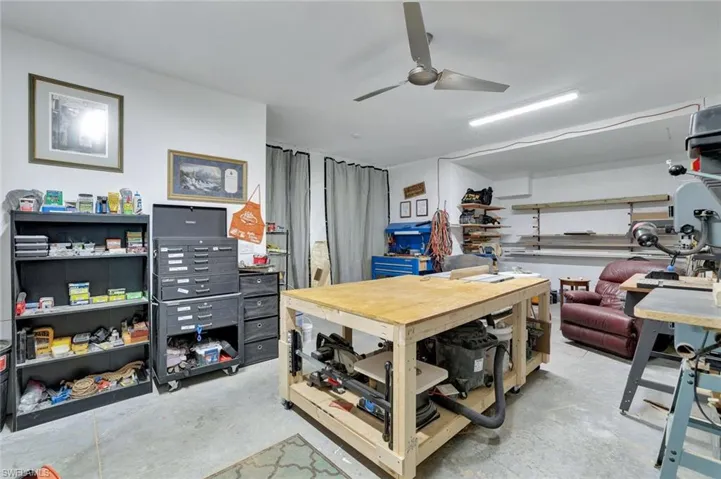 Home office featuring a workshop area, concrete floors, and ceiling fan
