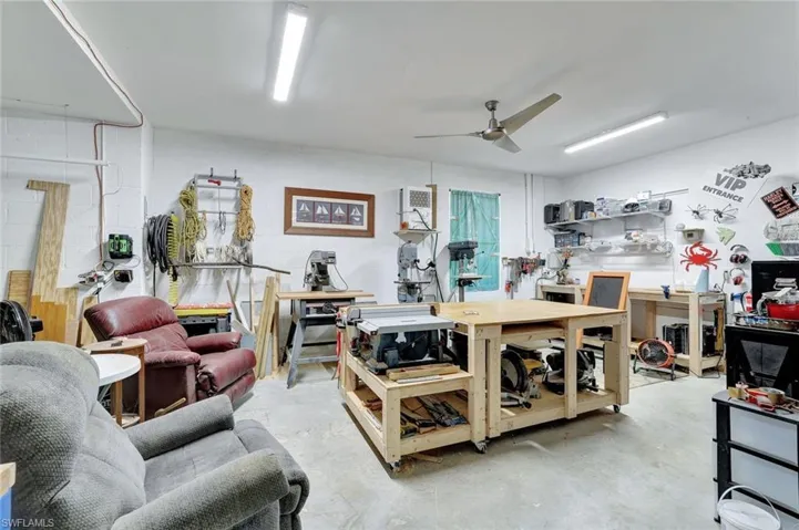 Misc room featuring a workshop area, unfinished concrete floors, and a ceiling fan