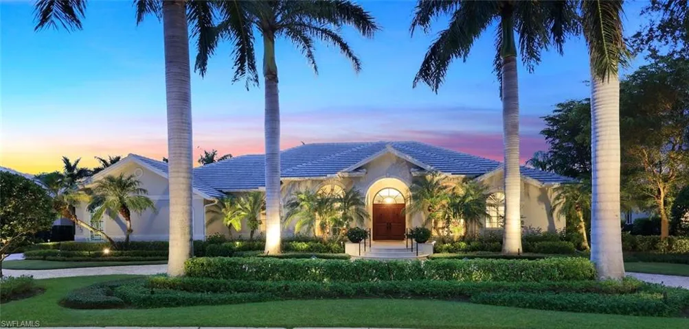 Grand front entrance with circular drive, professional landscaping and lighting