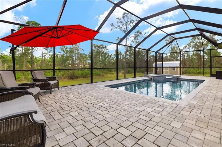 View of swimming pool with glass enclosure, cooling unit, and a patio area
