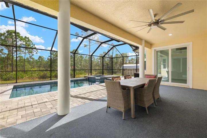 View of patio / terrace with ceiling fan, a pool with hot tub, and a lanai