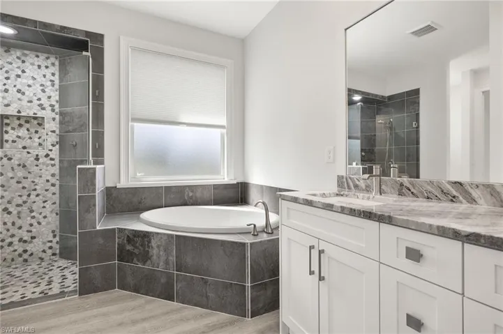 Bathroom with vanity, plus walk in shower, and hardwood / wood-style floors